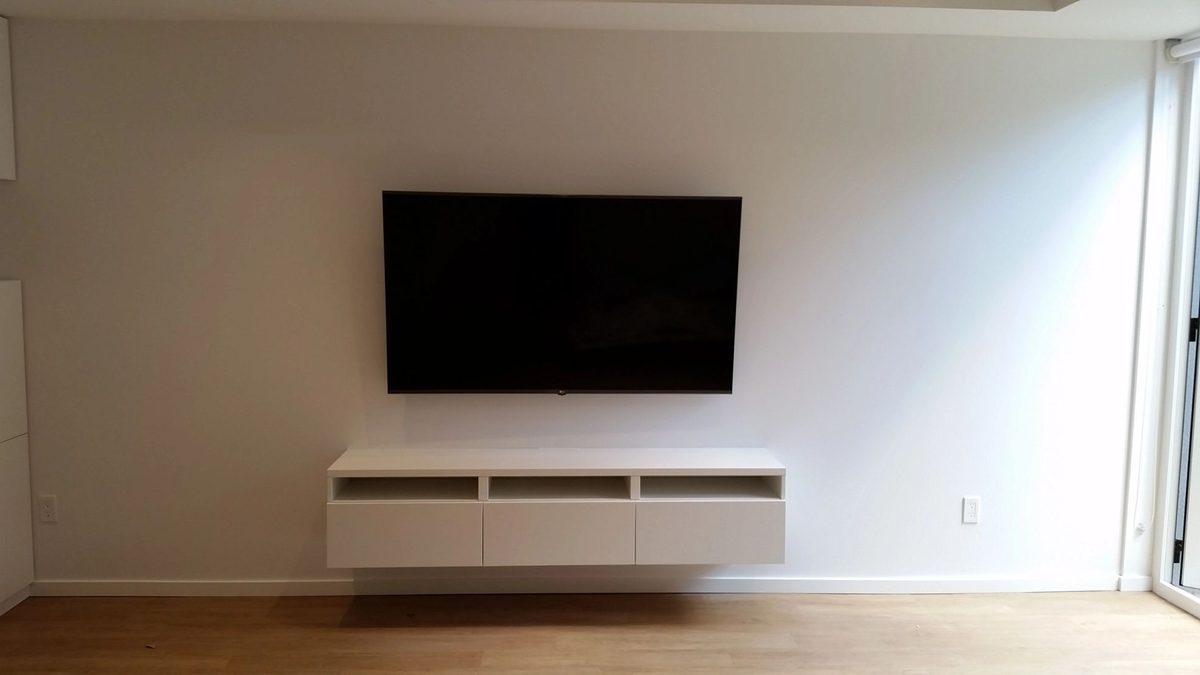 TV mounted above a floating console on a plain wall