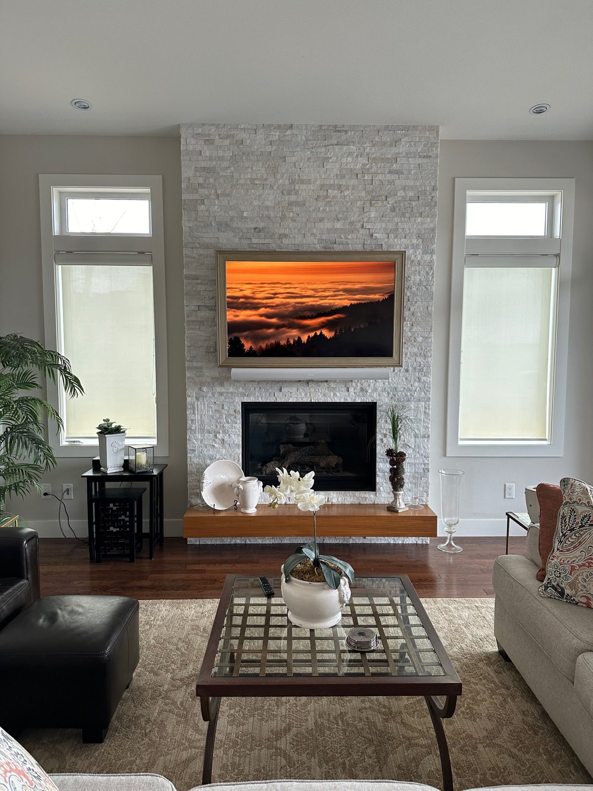 TV and soundbar on a floor to ceiling white stacked stone fireplace
